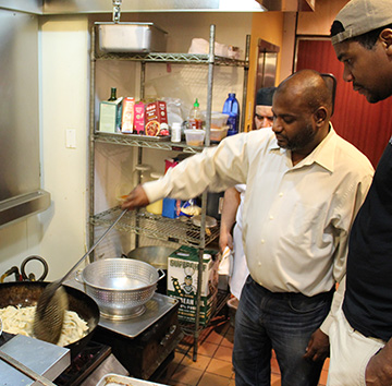 Bobby of Karma showing Jeremy how to cook